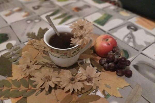 Натюрморт: чашка чаю, яблуко і осінні листочки